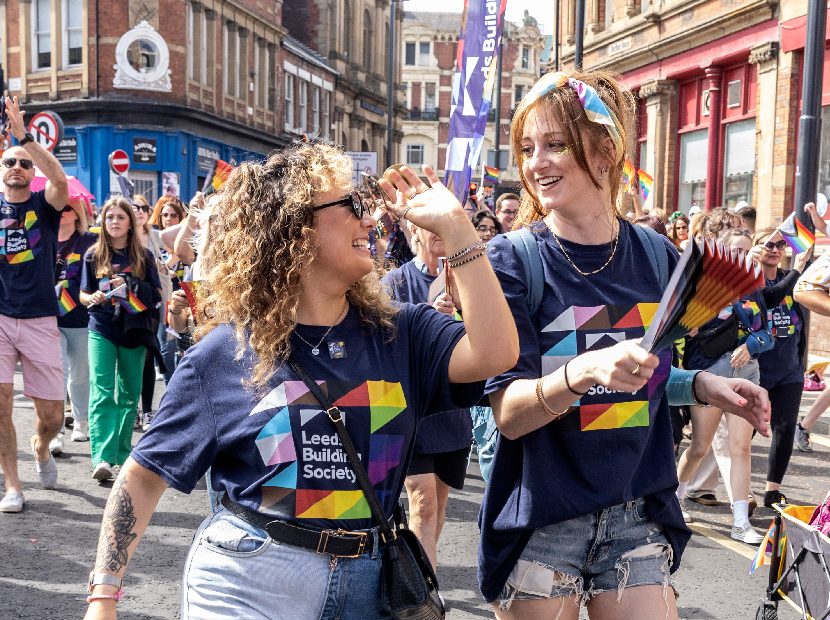 Two people smiling at each other at a Pride event